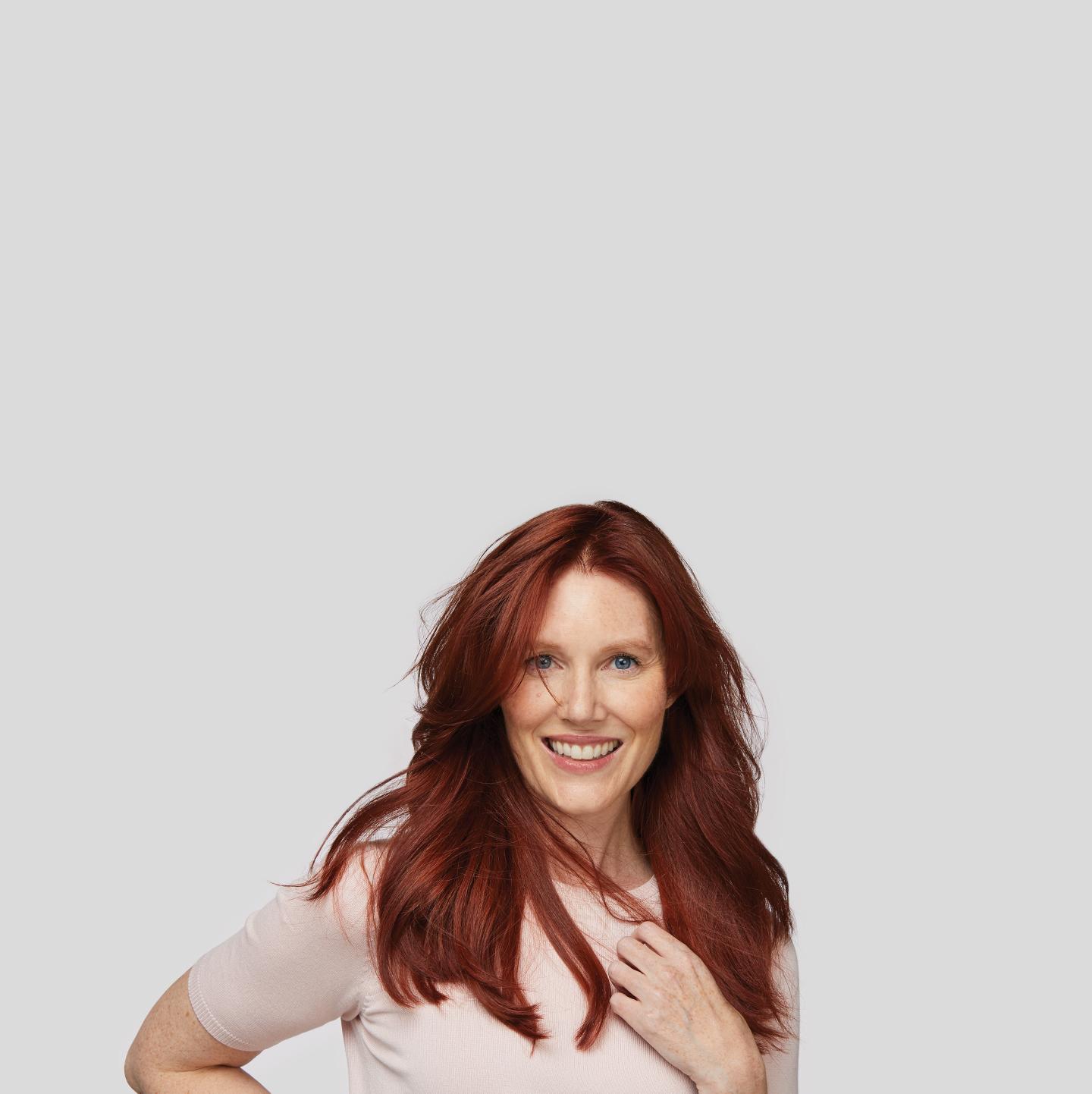 Woman with luxious red hair breaking a smile