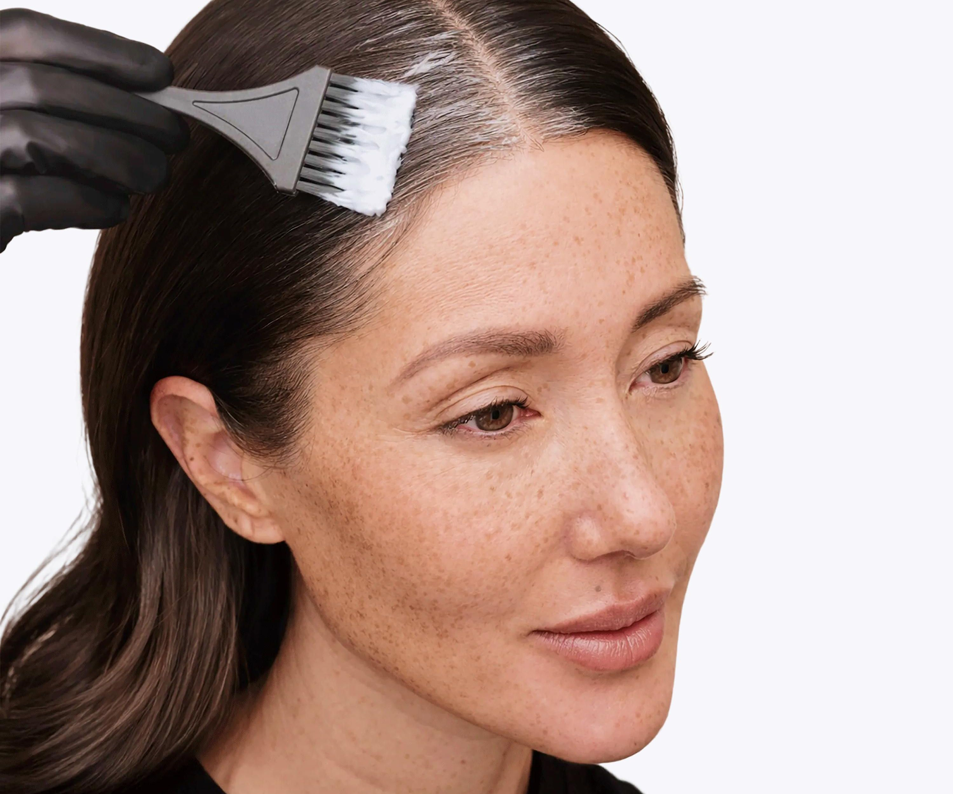 brown hair applying root perfection root touch up hair color to cover most visible roots and grays